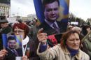 Pro-Russian activists hold pictures of ousted Ukrainian President Victor Yanukovich during a protest in central Donetsk