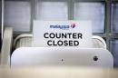 A closed desk of Malaysian airlines is seen at Schiphol airport in Amsterdam, Thursday, July 17, 2014. Ukraine said a passenger plane carrying 295 people was shot down Thursday as it flew over the country, and both the government and the pro-Russia separatists fighting in the region denied any responsibility for downing the plane. (AP Photo/Phil Nijhuis)