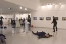 This picture taken on December 19, 2016 shows Andrei Karlov, the Russian ambassador to Ankara, lying on the floor after being shot by a gunman (R) during a public event in Ankara