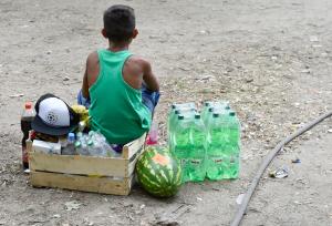 A young boy sits by food brought by citizens outside&nbsp;&hellip;