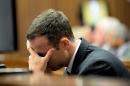 Oscar Pistorius buries his head in his hand as he listens to cross questioning, in the second week of his trial, about the events surrounding the shooting death of his girlfriend Reeva Steenkamp, in court during his trial in Pretoria, South Africa, Monday, March 10, 2014. Pistorius is charged with the shooting death of his girlfriend Steenkamp, on Valentines Day in 2013. (AP Photo/Bongiwe Mchunu, Pool)
