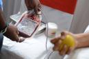 A medical volunteer (L) checks a blood bag after a rally on the observation of National Voluntary Blood Donation Day in Hyderabad on October 1, 2013