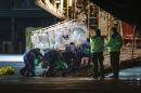 Medical personnel wheel a quarantine tent trolley containing Scottish healthcare worker Pauline Cafferkey, who was diagnosed with Ebola, into a Hercules Transport plane at Glasgow International Airport on December 30, 2014