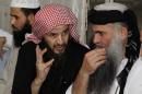 Radical Muslim cleric Abu Qatada listens to Islamist scholar Sheik Abu Mohammad al Maqdisi during a celebration after his release from a prison near Amman