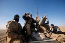 Shi'ite fighters ride in a military vehicle during a battle with Islamic State militants at the airport of Tal Afar