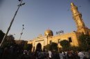 Egyptians stand outside El Sayeda Nafisa Mosque after funeral prayers for Shi'ite victims, who were killed in sectarian violence, in Cairo