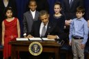 From left to right: Hinna Zeejah, 8, Taejah Goode, 10, Julia Stokes, 11, and Grant Fritz, 8, who wrote letters to President Barack Obama about the school shooting in Newtown, Conn., watch as Obama signs executive orders outlining proposals to reduce gun violence, Wednesday, Jan. 16, 2013, in the South Court Auditorium at the White House in Washington. (AP Photo/Charles Dharapak)