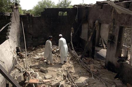 Residents stand inside a damaged house after a missile attack in Damadola village of the Bajaur tribal region in Pakistan May 15, 2008. REUTERS/Ammad Waheed