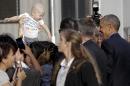 President Barack Obama smiles at a baby as he greets people as he arrives on Air Force One at John F. Kennedy International Airport, in New York, N.Y., Sunday, Sept. 18, 2016, en route to a Democratic National Committee event. (AP Photo/Carolyn Kaster)