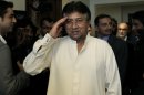 Former Pakistani President Pervez Musharraf salutes journalists as he arrives in his office for a press briefing before leaving to Karachi in Dubai, United Arab Emirates, Sunday, March 24, 2013. Musharraf gathered Sunday with supporters at Dubai's international airport for his planned return to his homeland after more than four years in self-exile. (AP Photo/Kamran Jebreili)