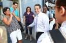 New York Gov. Andrew Cuomo, center, greets people during his visit in San Juan, Puerto Rico, Friday, Oct. 17, 2014. Cuomo took his campaign for a second term to the Caribbean Friday with stops in the Dominican Republic and Puerto Rico - two places with significant ties to the state Cuomo governs. (AP Photo/Jose R. Madera)