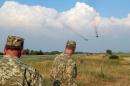 Ukrainian servicemen watch Sukhoi Su-24 front-line bombers fly during military aviation drills as Russia accuses Ukraine in incursion into annexed Crimea, in Rivne region