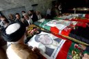 Mourners gather around the flag-draped coffins of six Afghan legislators at a military hospaital in Kabul