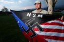 FILE - In this Oct. 22, 2010 file photo, Jeff Hall holds a Neo Nazi flag while standing at Sycamore Highlands Park near his home in Riverside, Calif. On Tuesday, Oct. 30, 2012, the trial begins in juvenile court for the 10-year-old boy charged with murder for shooting Hall, his white supremacist father while he slept on the couch in 2010. The child told investigators he killed his father with a gun kept unlocked in the family's home because he was tired of his father beating him and his stepmother. (AP Photo/Sandy Huffaker, File)