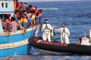 Child migrants are helped by rescuers during a rescue operation off the coast of Libya