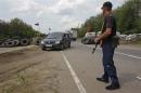A pro-Russian activist stops a car at a checkpoint outside village of Schastya