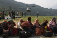 Evacuees cover their faces as an Indian Air Force helicopter prepares to land, in Ghauri Kund, on June 21, 2013. Relief teams were racing against time to rescue tens of thousands of stranded people in rain-ravaged northern India as the death toll from flash floods and landslides neared 600
