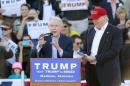 U.S. Senator Jeff Sessions speaks next to U.S. Republican presidential candidate Donald Trump at a rally at Madison City Schools Stadium in Madison