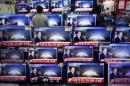 A sales assistant watches TV sets broadcasting a news report on North Korea's nuclear test, in Seoul