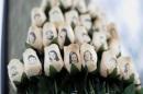 In this Jan. 14, 2013 file photo, white roses with the faces of victims of the Sandy Hook Elementary School shooting are attached to a telephone pole near the school on the one-month anniversary of the shooting that left 26 dead in Newtown, Conn. Newtown is taking its time to decide what a permanent memorial should look like. A commission has been hearing proposals for concepts including murals, groves and memorial parks, while looking for lessons from paths chosen by other tragedy-stricken communities. Public forums are planned for 2015, the next step in a process that is expected to last several more years. (AP Photo/Jessica Hill, File)