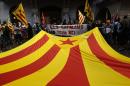 Pro-independence supporters hold banners and a Catalan independence flag during a demonstration against the monarchy and in favour of the independence of Catalonia in Girona, Spain on June 26, 2014