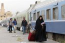 A passenger walks beside a train in a train station in Baghdad