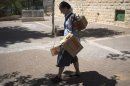 An Israeli woman carries gas masks as she leaves the distribution centre in Jerusalem on August 26, 2013