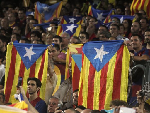 Spectators hold up Catalan pro-independence flags during the Spanish first division soccer match between Real Madrid and Barcelona at Nou Camp stadium in Barcelona