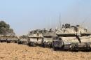 Israeli Merkava tanks, a D9 bulldozer and armoured personnel carriers roll near Israel's border with the Gaza Strip on July 17, 2014