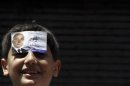 A boy sticks a flyer of Egyptian presidential candidate Ahmed Shafik on his forehead in Old Cairo