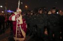 A person dressed up as Ded Moroz (Father Frost) passes police officers during an unsanctioned rally in downtown Moscow, Russia, Monday, Dec. 31, 2012. The Russian opposition protests on the 31st of each month are a nod to the 31st article of the Russian constitution, which guarantees the right of assembly. (AP Photo/Alexander Zemlianichenko)