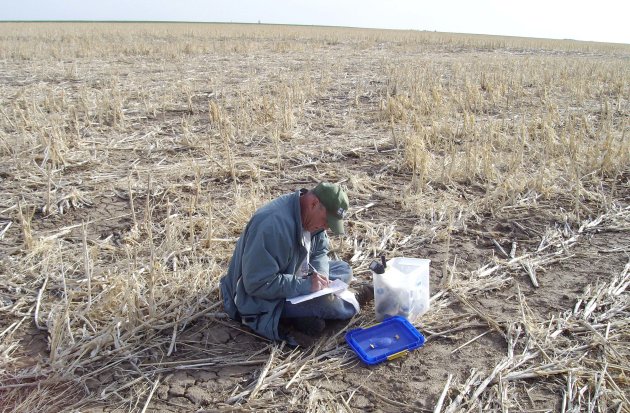 In this photo taken April 16, 2008, and provided by the U.S. Geological Survey, geologist Jim Kilburn, now retired from the U.S. Geological Survey, collects soil from Kansas. The federal government sent students and scientists to more than 4,800 places across the nation to collect soil that was analyzed for its composition. The results are now highly sought after by researchers in a wide variety of fields. (AP Photo/U.S. Geological Survey)