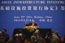 Australia's Treasurer Joe Hockey (C) holds up his pen as he becomes the first to sign articles of association to help set up the Asian Infrastructure Investment Bank during a ceremony at the Great Hall of the People in Beijing, June 29, 2015