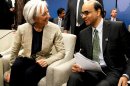 International Monetary Fund (IMF) Managing Director Christine Lagarde, left, talks with IMFC Chair Tharman Shanmugaratnam during the World Bank IMF Spring Meetings in Washington, Saturday, April 20, 2013. (AP Photo/Molly Riley)