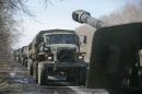 Trucks of the separatist self-proclaimed Donetsk People's Republic army towing mobile artillery cannons, are seen as they pull back from Donetsk