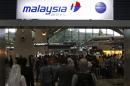 Passengers queue up at the Malaysia Airlines ticketing booth at the Kuala Lumpur International Airport in Sepang