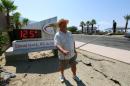 Palm Springs resident Benito Almojuela takes a selfie near a thermometer sign which reads 125 degrees in Palm Springs, California