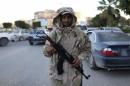 A member of the Libyan army stands guard along a street following yesterday's clashes in Benghazi
