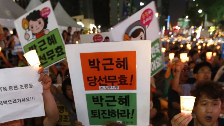 People attend a candle-light demonstration held to demand for South Korean President Park to apologise to the nation and to call for the resignation of NIS chief Nam in central Seoul