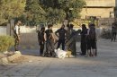 Free Syrian Army members gather on a street as they prepare an improvised rocket launcher in Deir al-Zor