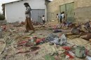 People inspect the site of a suicide bombing in Yemen's southern city of Jaar