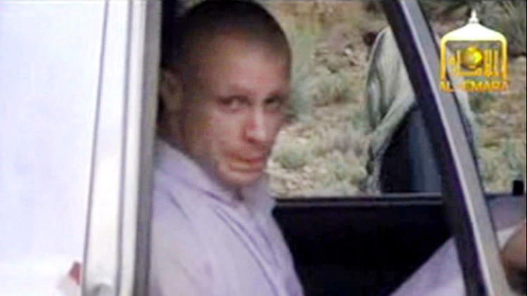 In this image taken from video obtained from Voice Of Jihad Website, which has been authenticated based on its contents and other AP reporting, Sgt. Bowe Bergdahl sits in a vehicle guarded by the Taliban in eastern Afghanistan. The Taliban have released a video showing the handover of Bergdahl to U.S. forces in eastern Afghanistan. The video, emailed to media on Wednesday, shows Bergdahl in traditional Afghan clothing sitting in a pickup truck parked on a hillside. More than a dozen Taliban fighters with machine guns stand around the truck and on the hillside. (AP Photo/Voice Of Jihad Website via AP video)