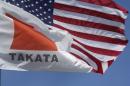 A flag with the Takata logo flies alongside an American flag outside the Takata Corporation in Auburn Hills