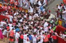 Runners trip and fall ahead of the bulls blocking the entrance to the bullring during the running of the bulls of the San Fermin festival, in Pamplona, Spain, Saturday, July 13, 2013. A total of 21 persons have been injured, two by gorings, as thousands of daredevils raced through the crowded streets of Pamplona in a hair-raising running of the bulls that ended in a crush on Saturday.(AP Photo/Joseba Etxeberria)