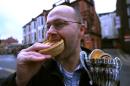 File photo for illustration shows a man eating a pie in Wigan, northern England, on December 15, 2009