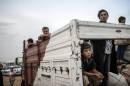 Syrian Kurds, fleeing an onslaught by the jihadist Islamic State group, sit in a truck as they cross the border into Turkey at the southeastern town of Suruc, on September 27, 2014