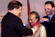Indian sitar maestro Pandit Ravi Shankar (C) receives France's highest civilian award, the Commander of the Legion of Honor from then the French Ambassador to India, Claude Blanchemaison (L), on February 12, 2000
