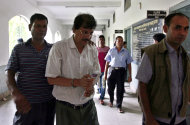 In this Friday, May 3, 2013 photo, engineer Abdur Razzak Khan, center, is detained by police in Dhaka, Bangladesh. The death toll in the factory-building collapse in Bangladesh rose to more than 530 on Saturday. Police official Ohiduzzaman said Friday that engineer Abdur Razzak Khan was arrested a day earlier on a charge of negligence related to the building collapse. He said Khan worked as a consultant to Rana Plaza owner Mohammed Sohel Rana when the illegal three-floor addition was made to the building. (AP Photo)