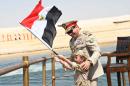 In this picture provided by the office of the Egyptian Presidency, Egyptian President Abdel-Fattah el-Sissi smiles at a boy dressed in a tiny military uniform as he waves the national flag from a monarchy-era yacht that sailed to the venue of a ceremony unveiling a major extension of the Suez Canal in Ismailia, Egypt, Thursday, Aug. 6, 2015. El-Sissi has billed the extension as an historic achievement needed to boost the country's ailing economy after years of unrest. (Egyptian Presidency via AP) MANDATORY CREDIT