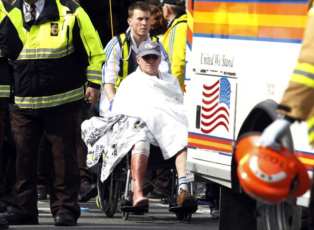 A runner in a wheelchair is taken from a triage tent after explosions went off at the 117th Boston Marathon in Boston